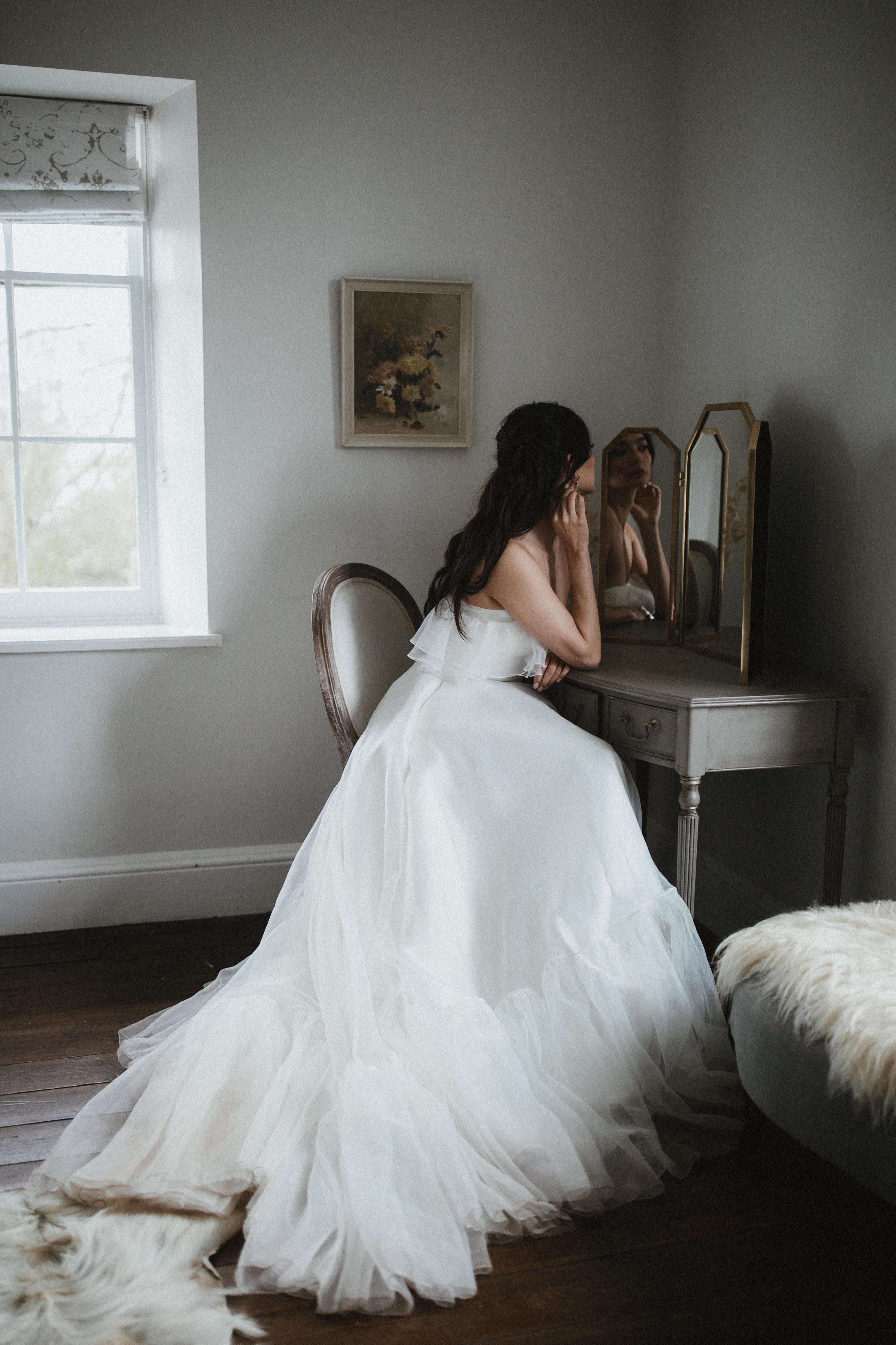 Model wearing our Monroe wedding dress, a structured, corseted organza dress with frill, bardot neckline and pockets.